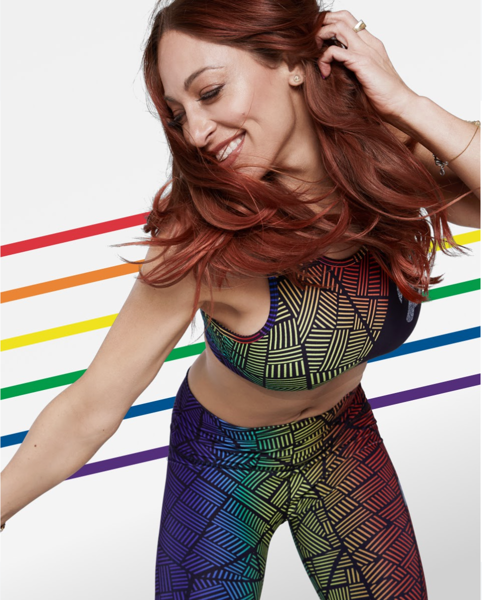 Peloton Pride Collection — a member wearing a rainbow geometric-pattern sports bra and leggings.